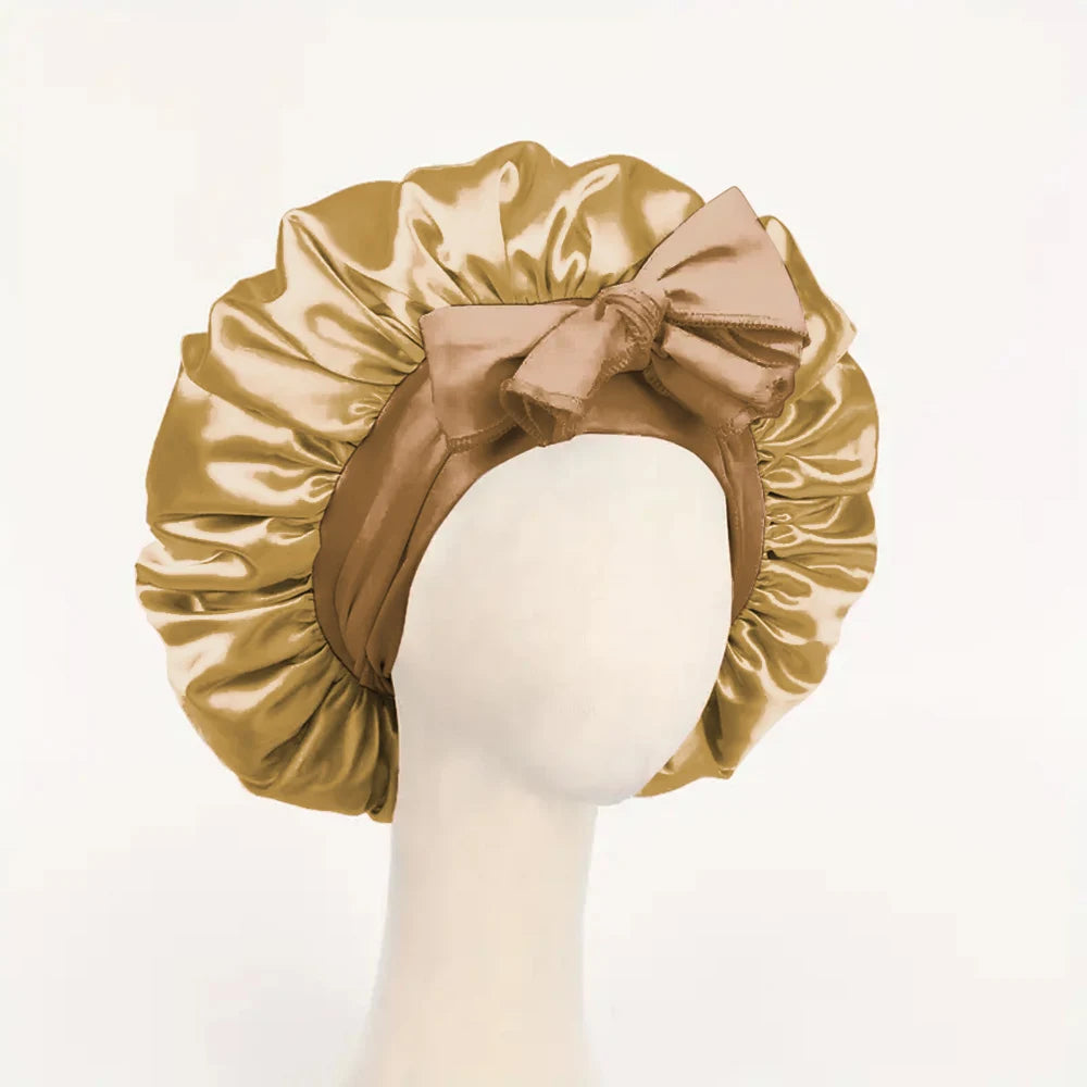 Adjustable satin bonnet for sleeping in golden beige with a bow detail on a mannequin head