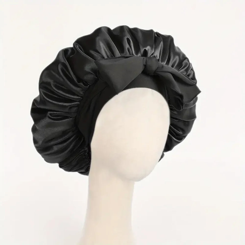 Black adjustable satin bonnet for sleeping with a bow tie on a mannequin head