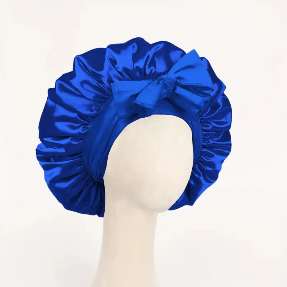 Blue adjustable satin bonnet for sleeping with a large tied bow designed for hair protection