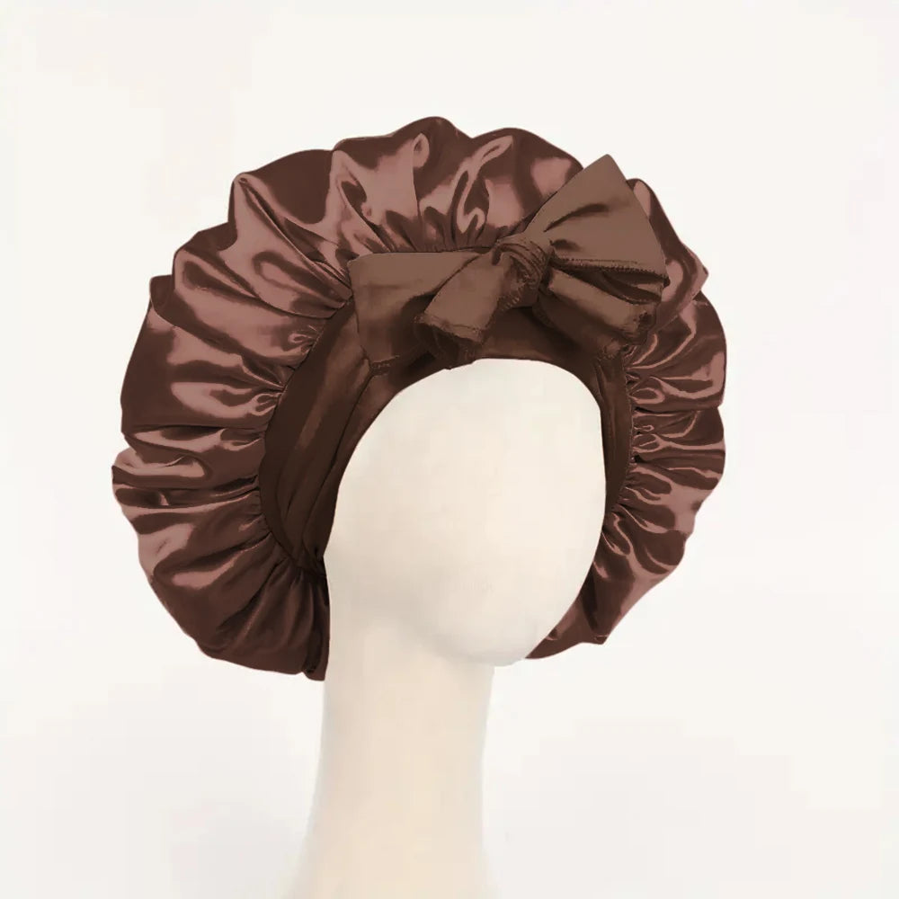 Brown adjustable satin bonnet for sleeping with a large bow detail on a mannequin head