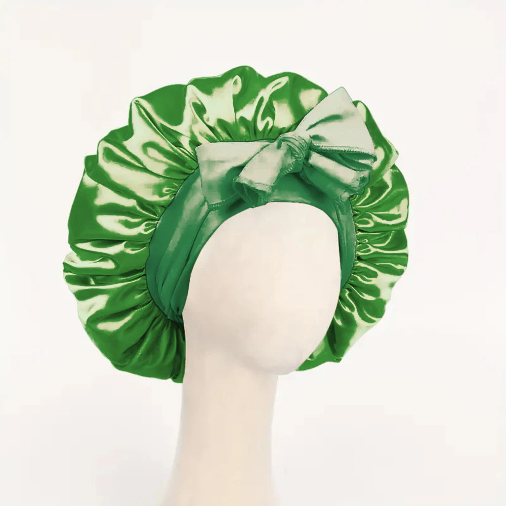 Green adjustable satin bonnet for sleeping with a large bow on a mannequin head