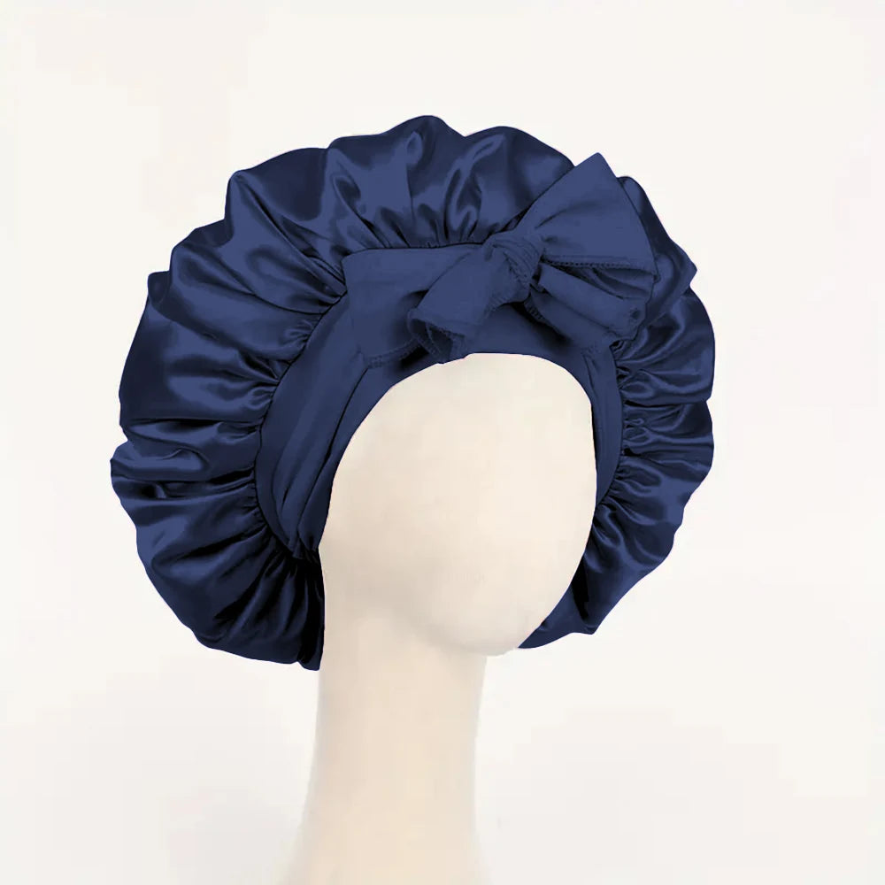 Navy blue adjustable satin bonnet for sleeping with a front bow on a mannequin head