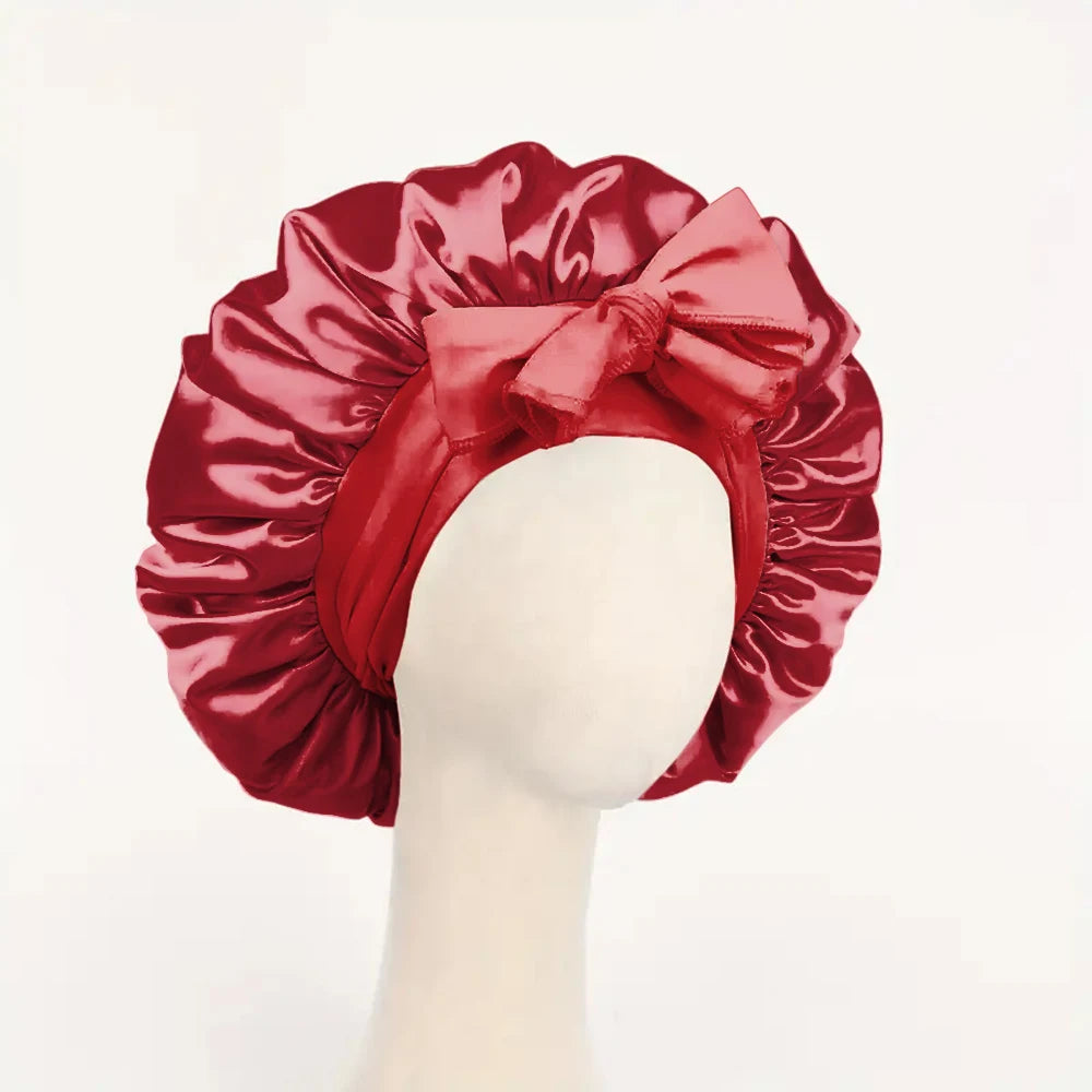 Red adjustable satin bonnet for sleeping with large bow detail on white mannequin head