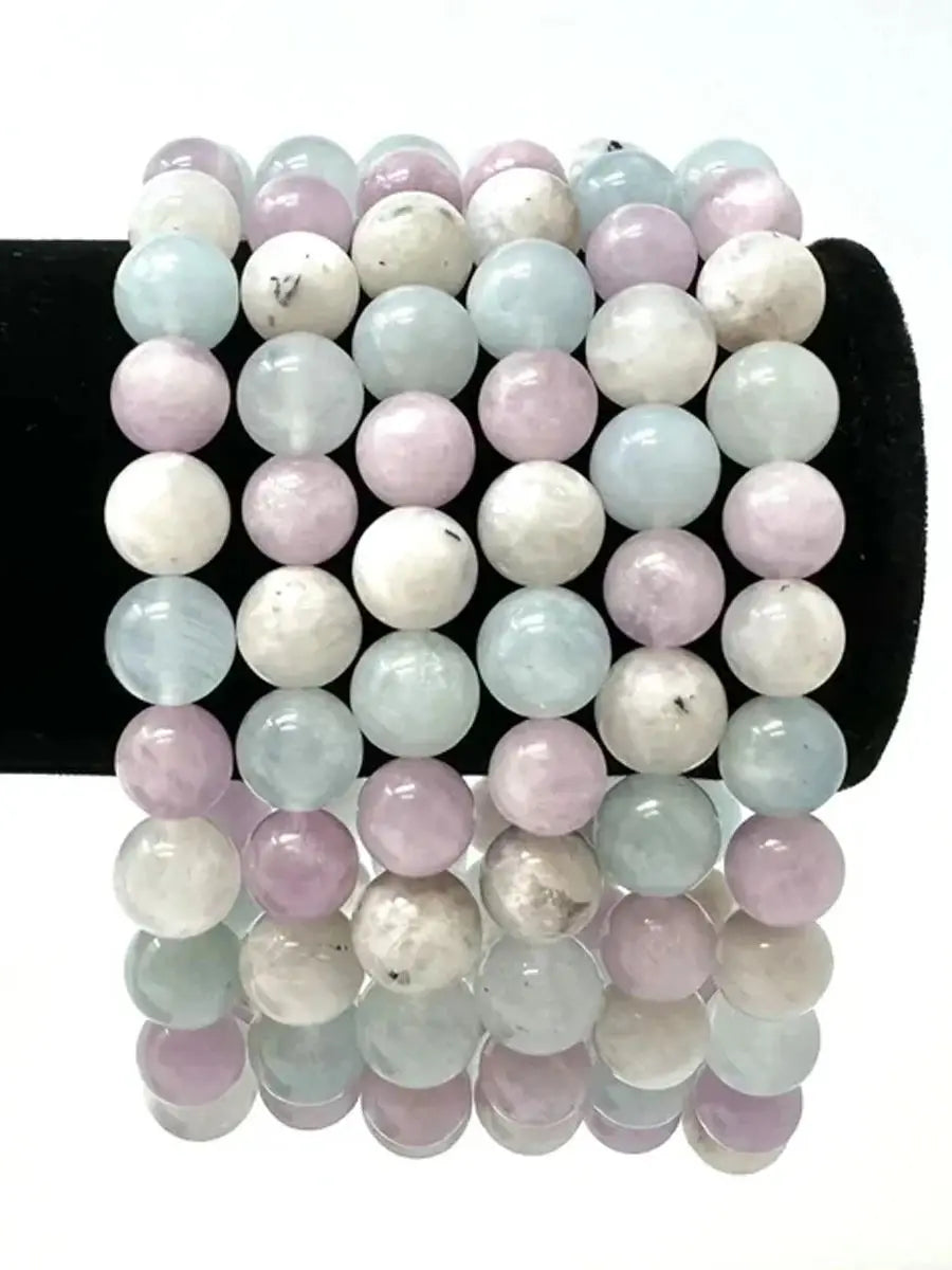 Set of pastel crystal bracelet for mindfulness practice with soft pink, blue, and white beads on black display
