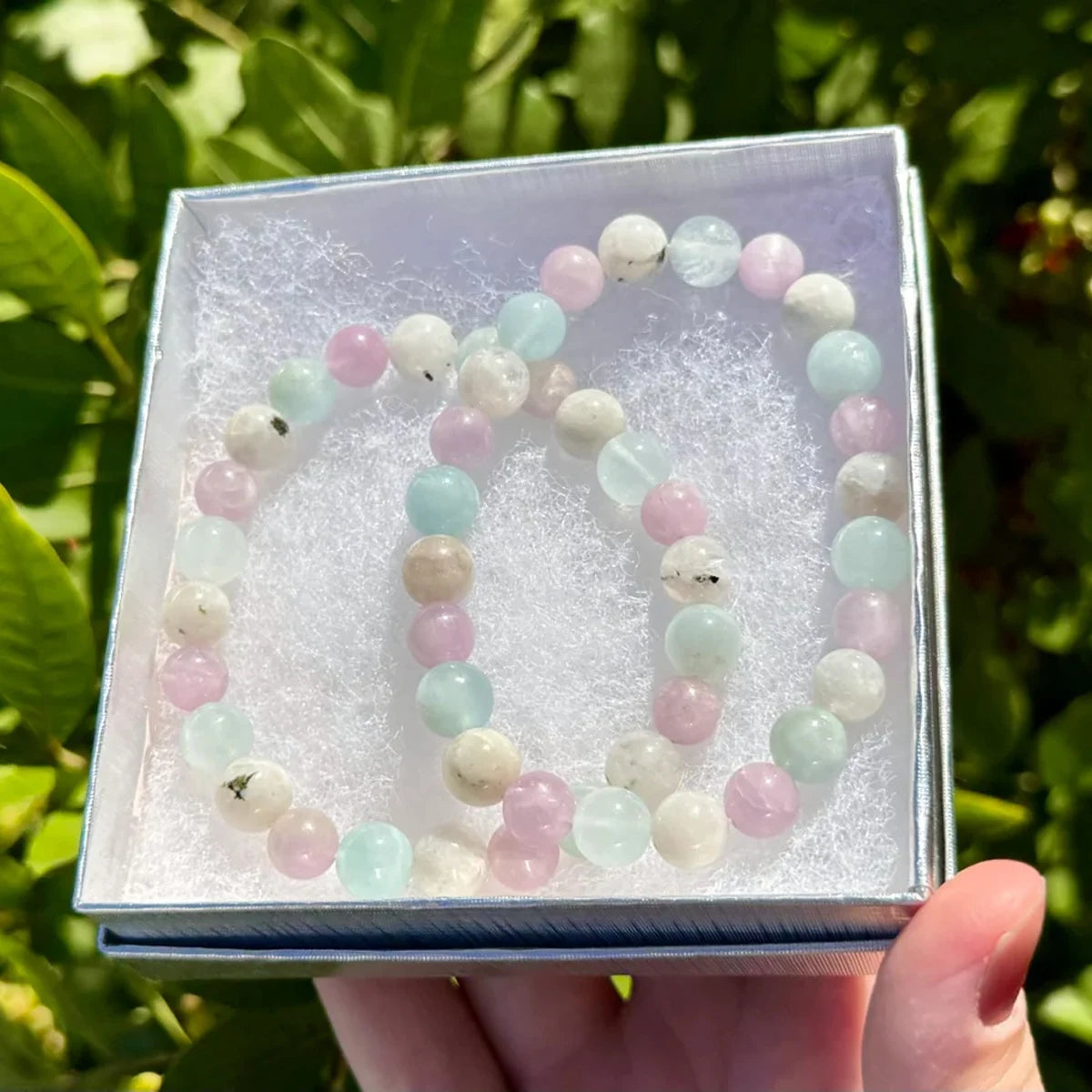 Crystal bracelet for mindfulness practice with pastel-colored beads in a gift box held by hand