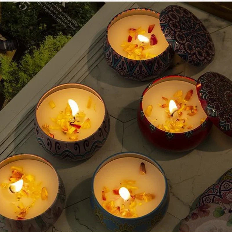 Islamic pattern scented candles lit with petals in decorative round tins on marble surface