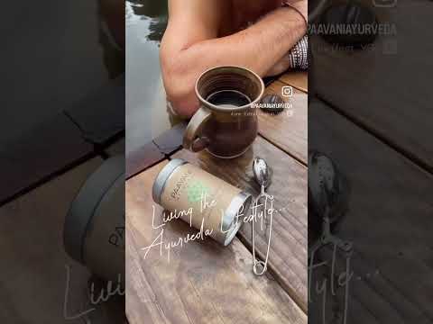 Organic loose leaf herbal tea container with a ceramic mug and spoon on a wooden surface by DC-PAAVANI Ayurveda