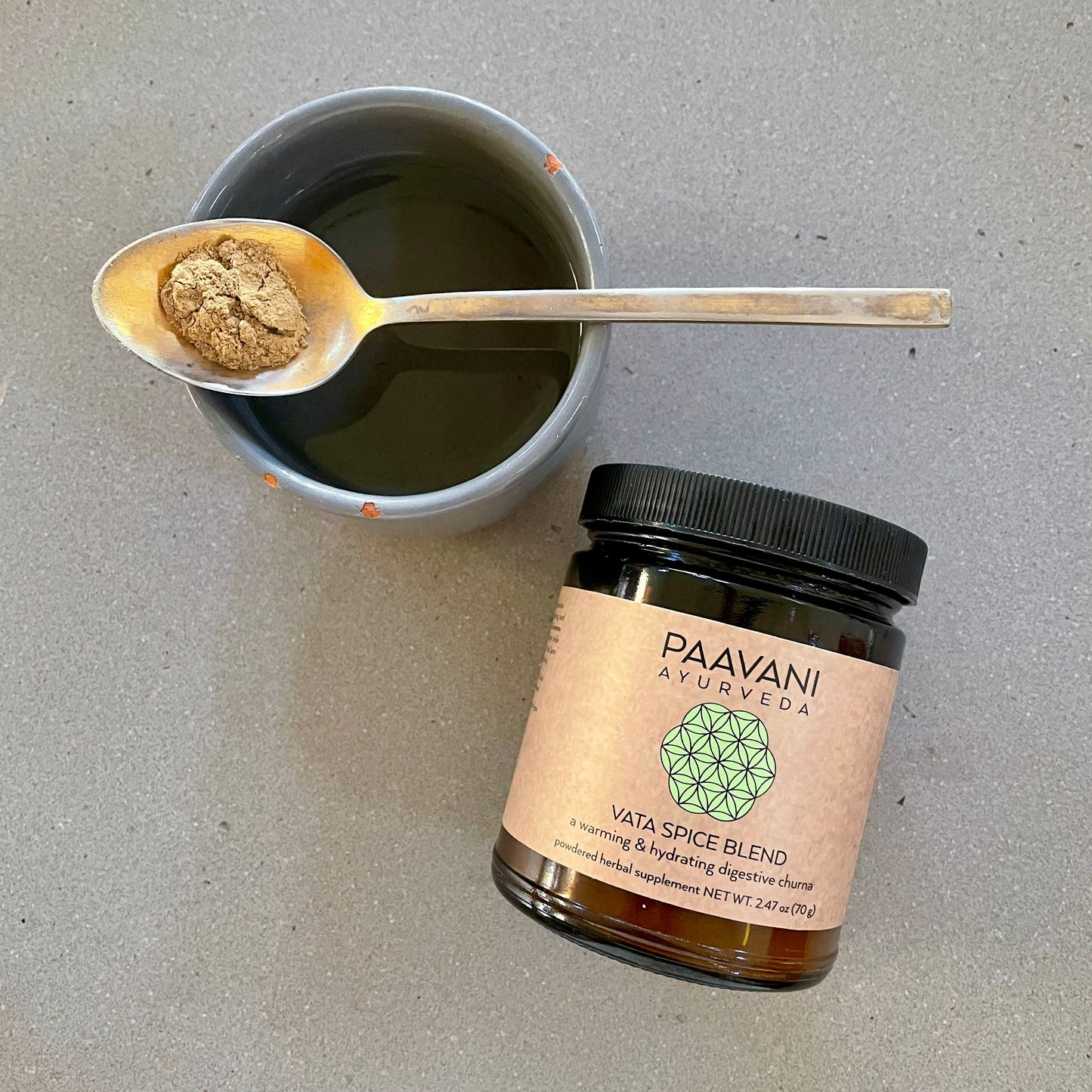PAAVANI Ayurveda Vata spice blend for digestion in glass jar with spoonful of powder over cup