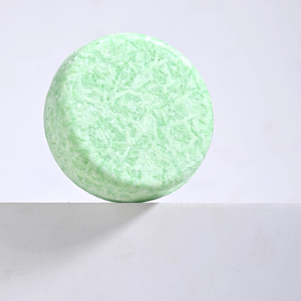 Sacred Self Wellness tea tree oil shampoo bar in light green round shape for natural hair care
