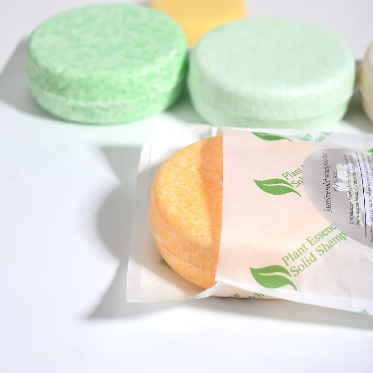Tea tree oil shampoo bar by Sacred Self Wellness with green and yellow solid shampoo bars in background
