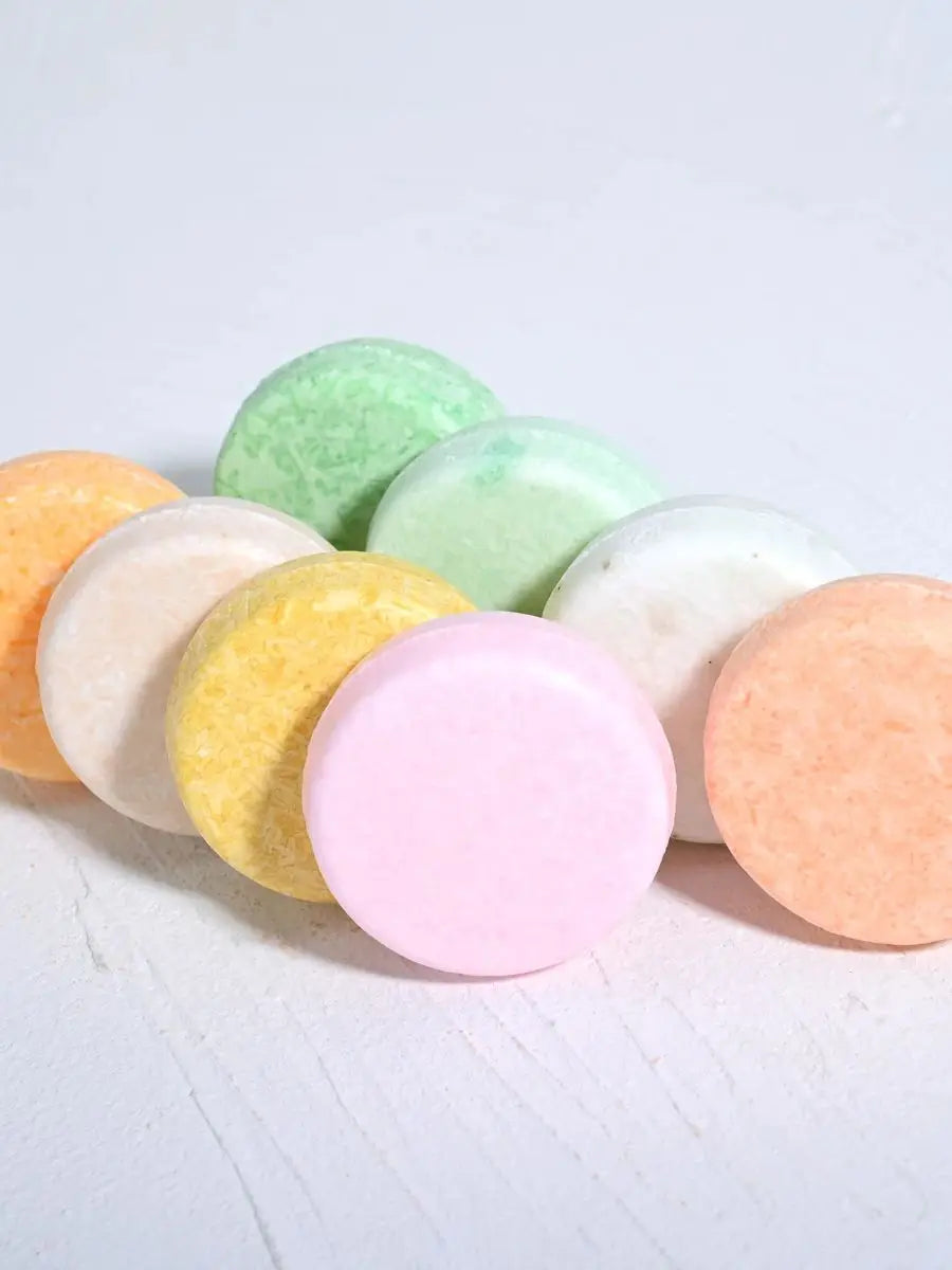 SACRED SELF WELLNESS colorful tea tree oil shampoo bars arranged on a white surface