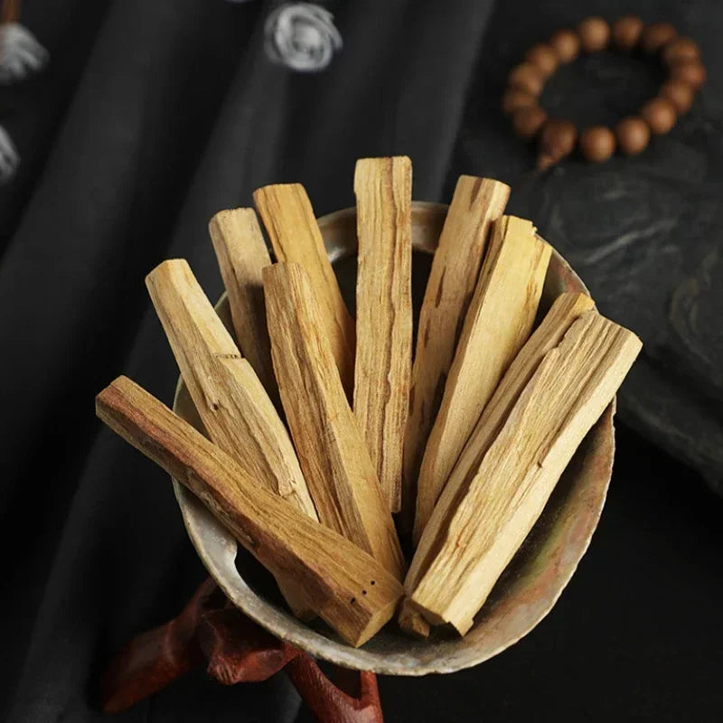 Natural palo santo incense sticks arranged in a bowl by SACRED SELF WELLNESS for cleansing and meditation