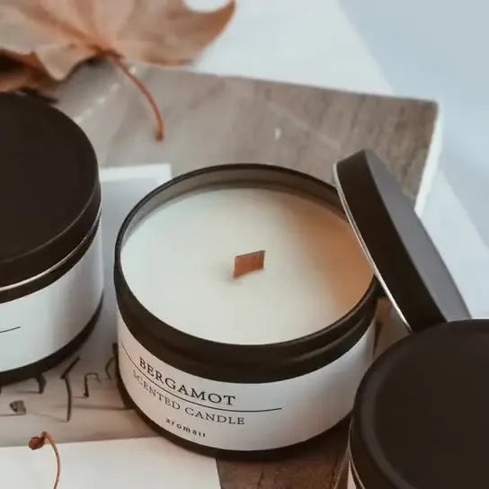 Bergamot scented candle with dried flowers in a black jar with wooden wick and lid