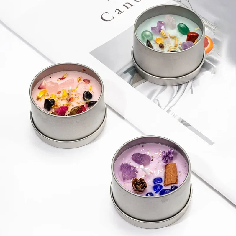 Set of three scented candles with dried flowers and colorful stones in silver tins