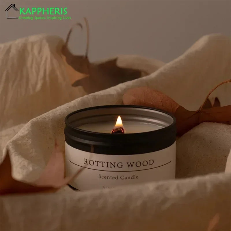 Scented candle with dried flowers labeled Rotting Wood burning on beige fabric background