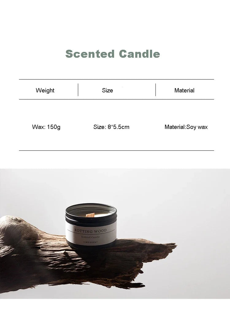 Scented candle with dried flowers in a black jar made of soy wax placed on a piece of wood
