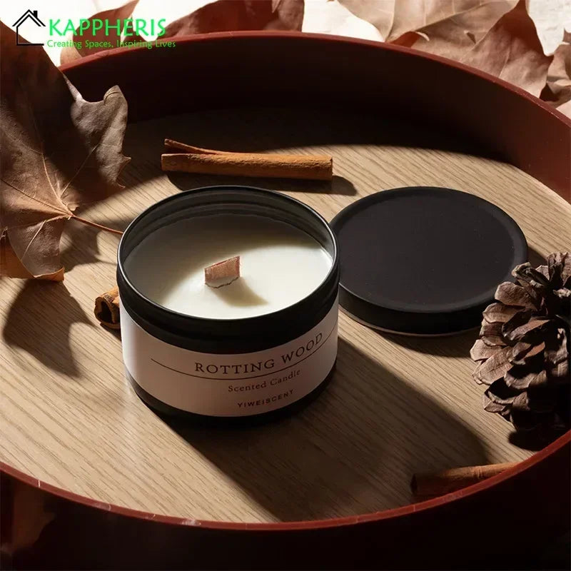 Scented candle with dried flowers in a black tin container labeled Rotting Wood on wooden tray