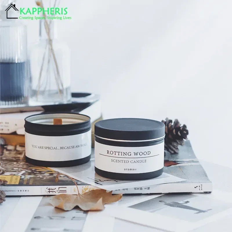 Black scented candle with dried flowers in tin containers on books with natural decor