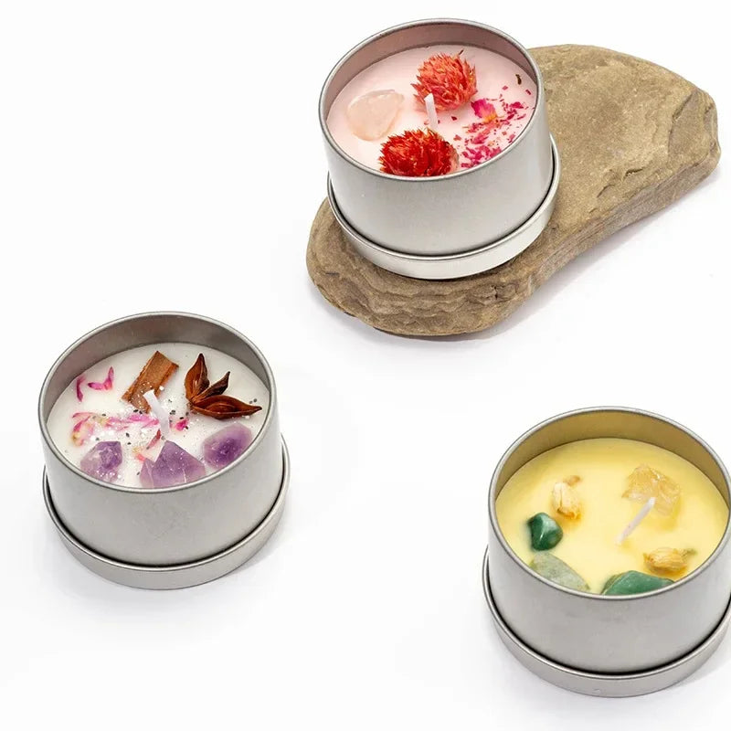 Set of three scented candle with dried flowers in silver tin containers with various colorful dried flower accents