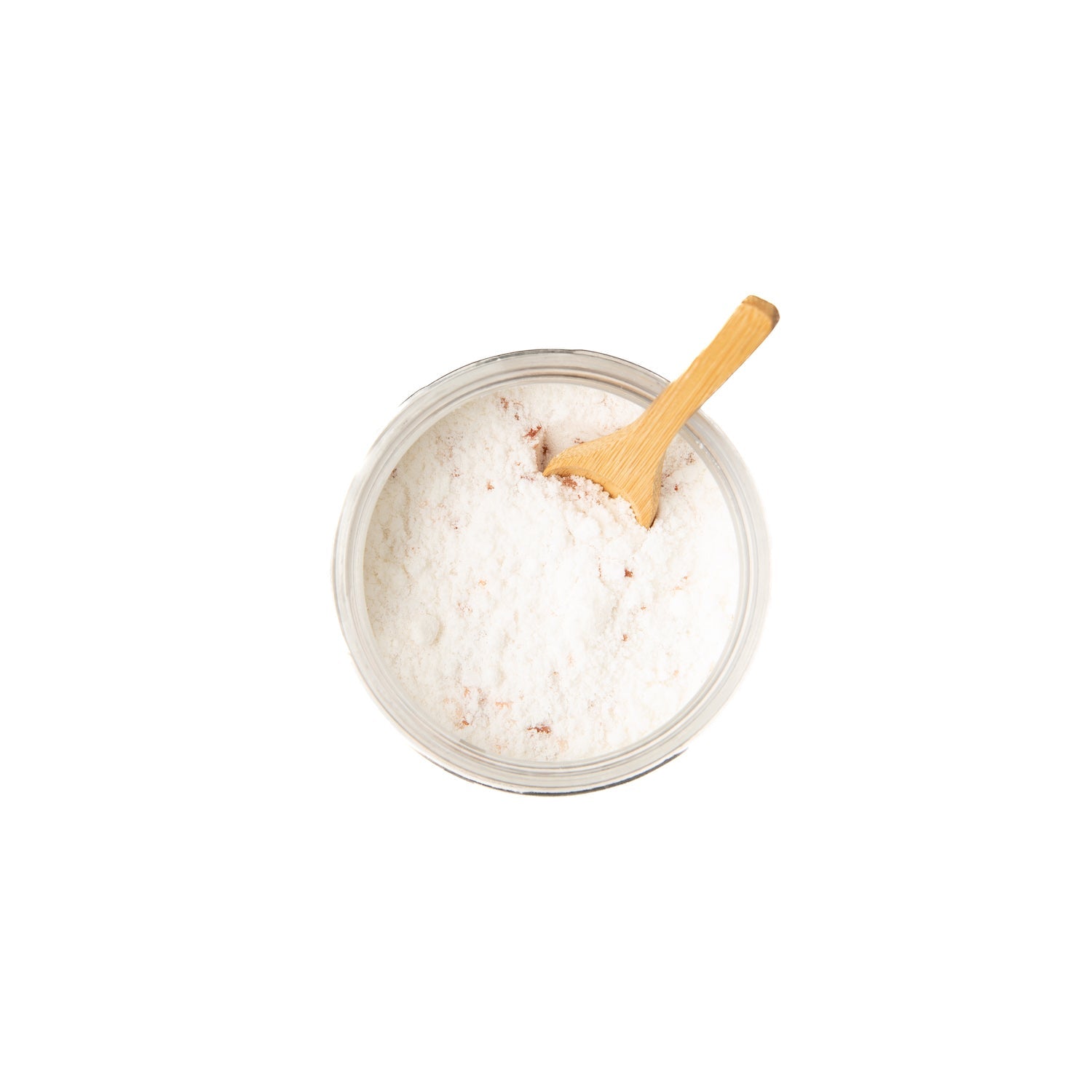 Jar of Ayurvedic coconut milk bath powder with wooden spoon on white background