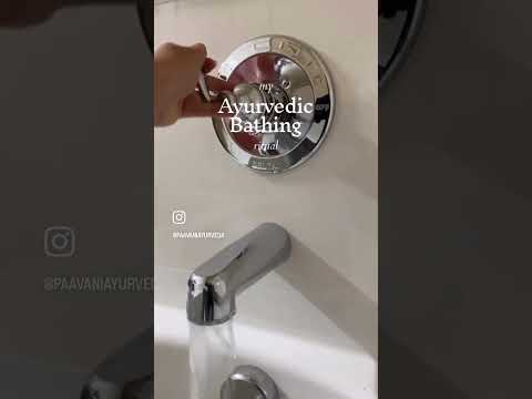Hand adjusting water temperature on bathtub faucet for Ayurvedic coconut milk bath by DC-PAAVANI Ayurveda