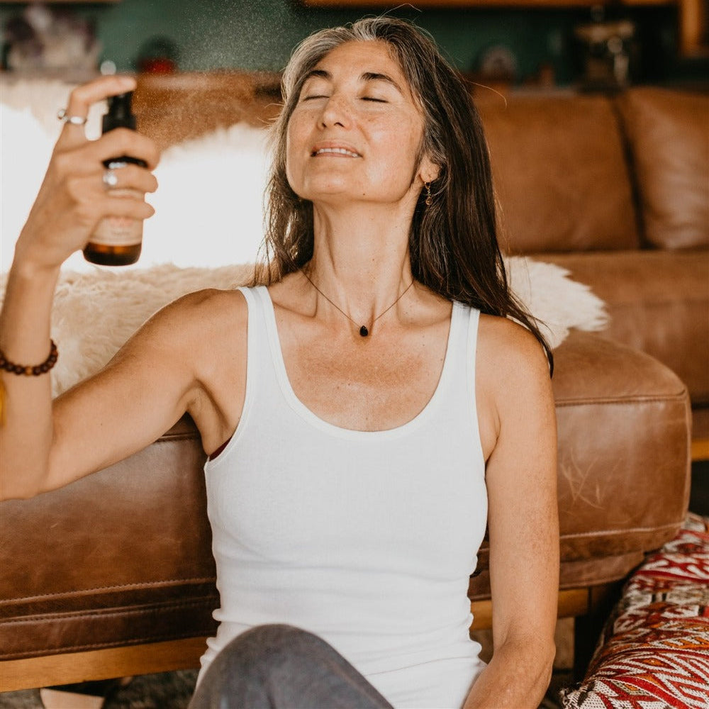 Woman using ayurvedic menopause support spray for natural wellness and relief at home