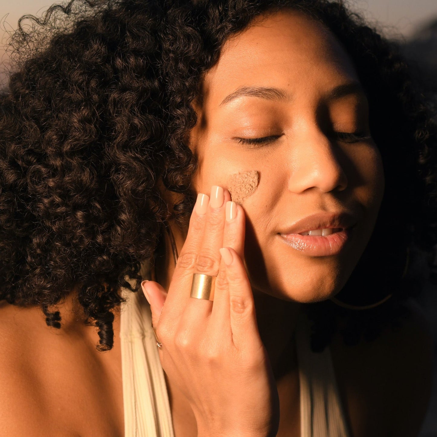 Woman applying natural cream on her face demonstrating Ayurvedic skin care class by DC-PAAVANI Ayurveda
