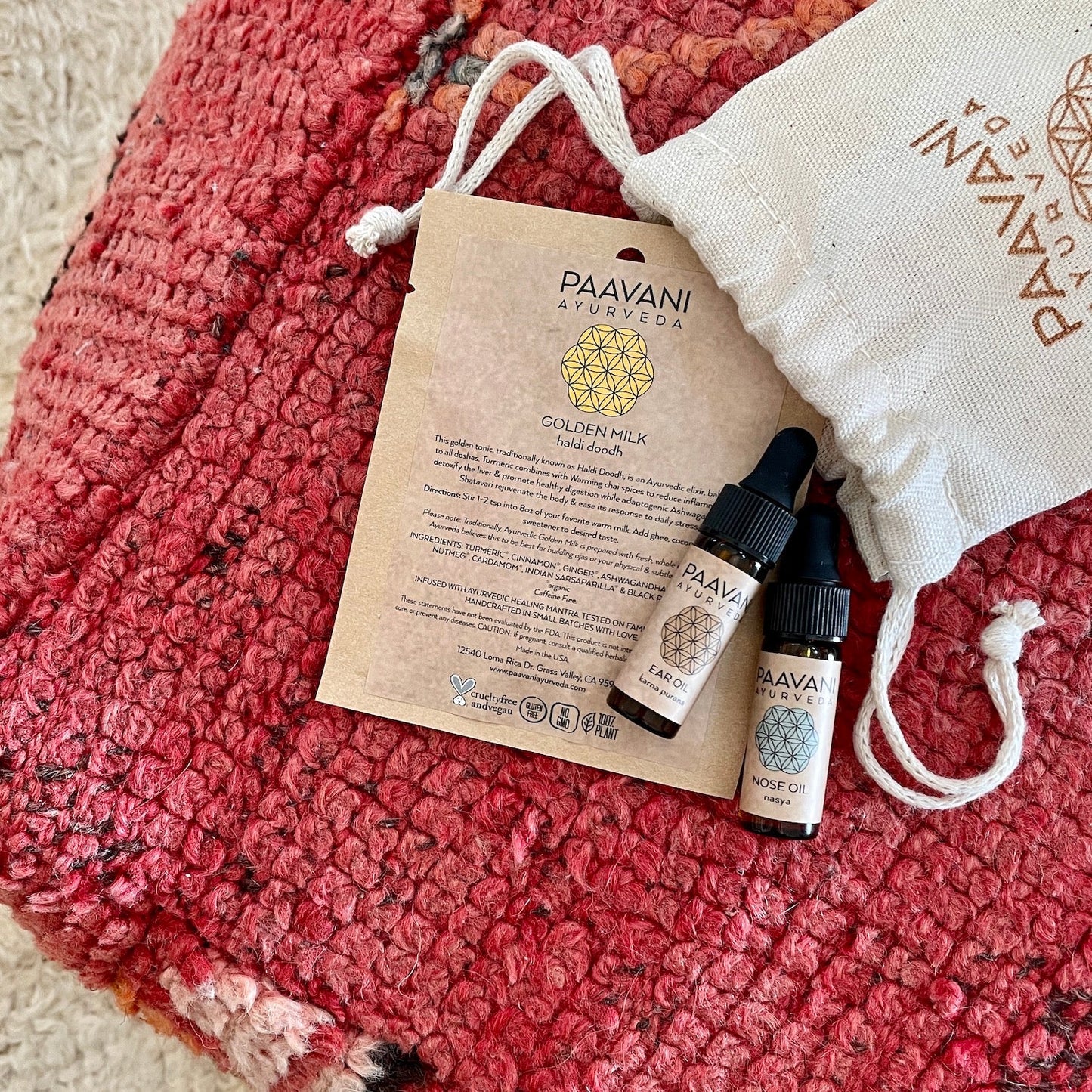 DC-PAAVANI Ayurveda Ayurvedic winter wellness kit with golden milk hand drops and oils on red textured fabric