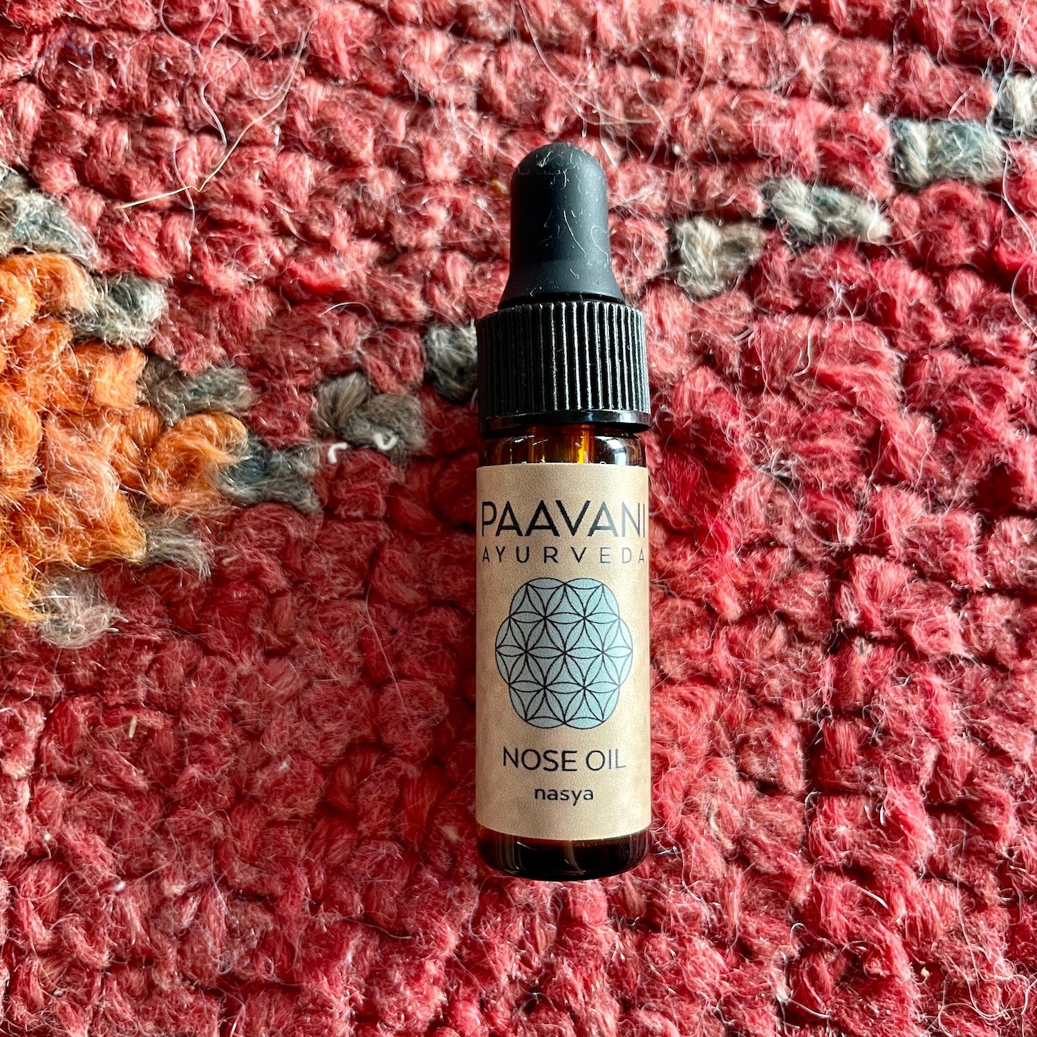 DC-PAAVANI Ayurveda nose oil bottle on textured red and orange background Ayurvedic winter wellness kit