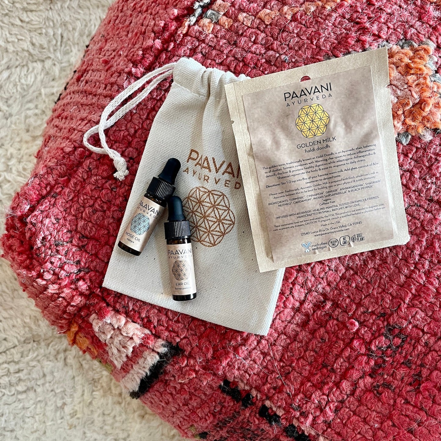 DC-PAAVANI Ayurveda Ayurvedic winter wellness kit with herbal oils and golden milk sachet on a red textured cloth