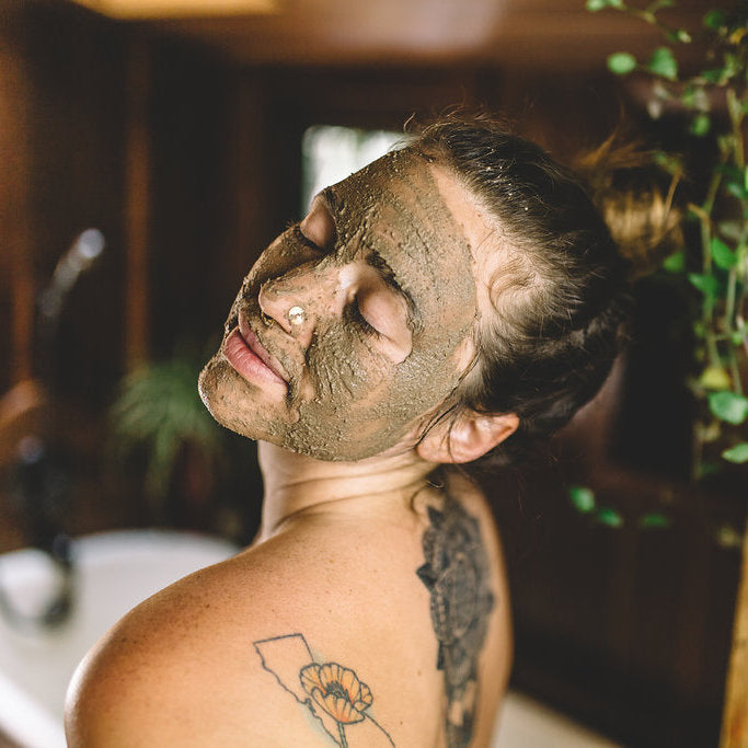Woman with a green herbal face mask applied using Kapha facial ritual kit by DC-PAAVANI Ayurveda