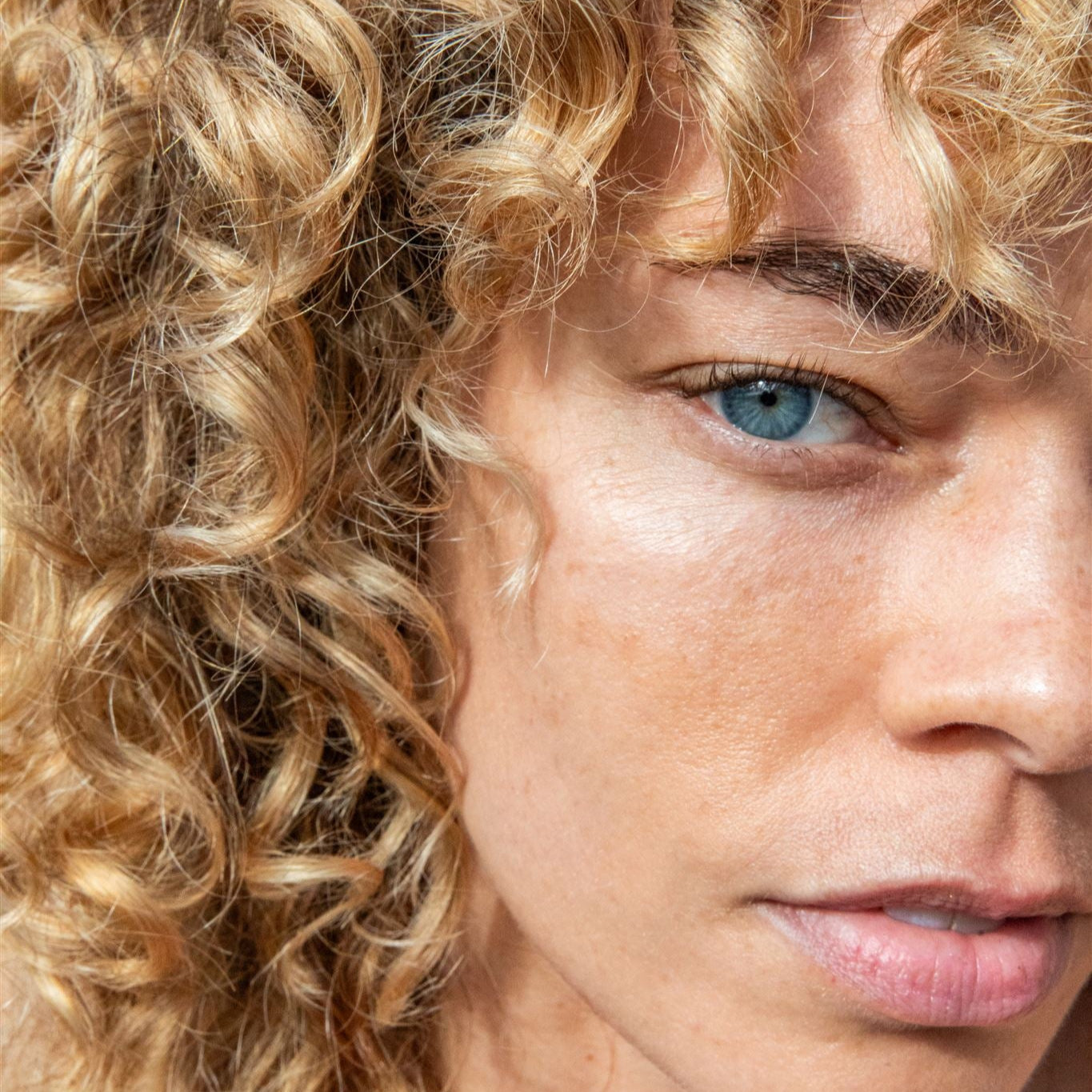 Close-up of woman with natural curly hair and clear skin showcasing Pitta balancing face mask benefits